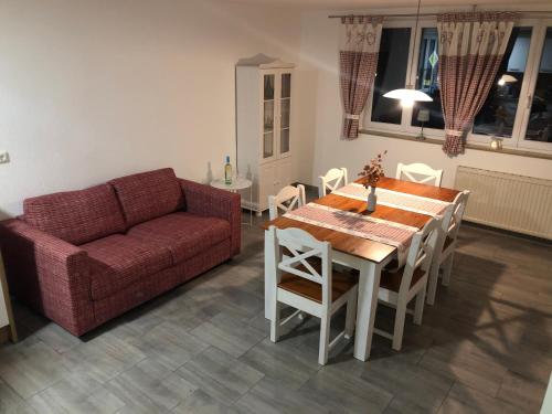 a living room with a couch and a table and chairs at AlbTraum in Reutti