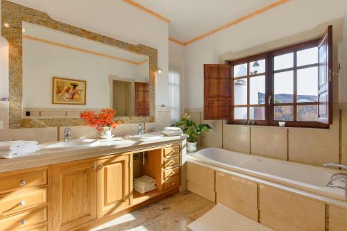 een badkamer met een bad en een grote spiegel bij Finca Remedios in Los Valles