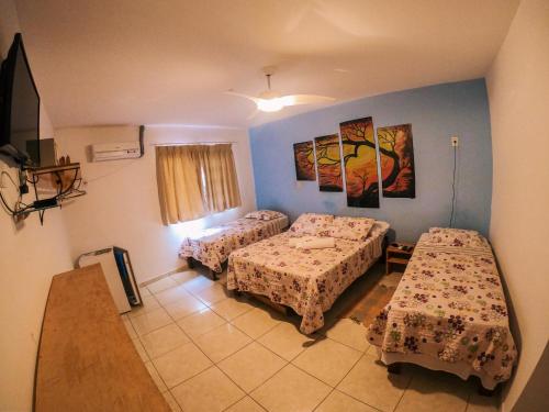 a room with two beds and a table in it at Pousada Bons Lençóis in Lençóis