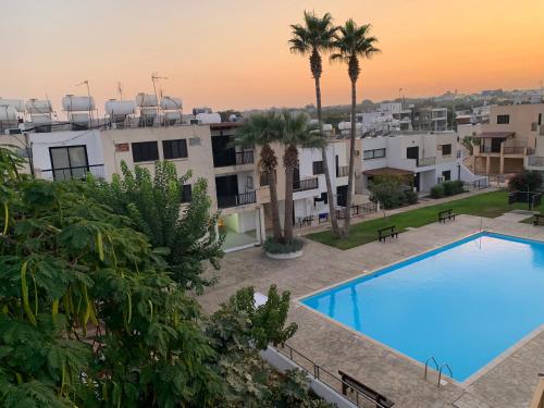 an apartment with a swimming pool and palm trees at Theodoros Apt. 408 in Protaras