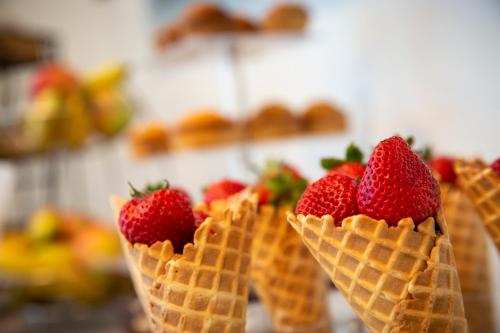 a row of ice cream cones with strawberries in them at Athens Central Hotel in Athens