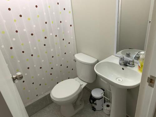 a white bathroom with a toilet and a sink at Home near Pimentel beach with parking in Chiclayo