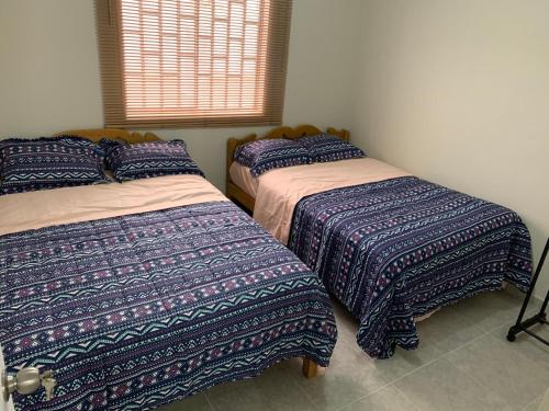 奇克拉約的住宿－Home near Pimentel beach with parking，一间卧室设有两张床和窗户。