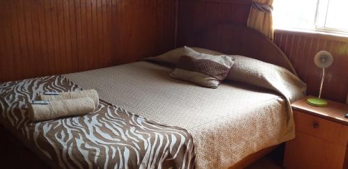 a bed with pillows on it in a room at Hostal Tunquelen in Valparaíso