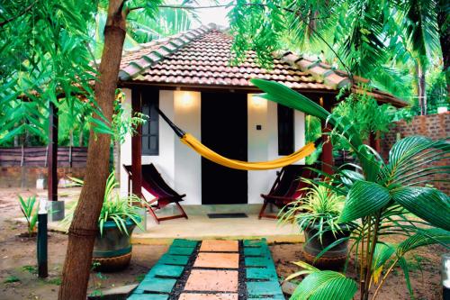 a house with a yellow hammock in front of it at Star Light Cabanas & Restaurant in Tangalle