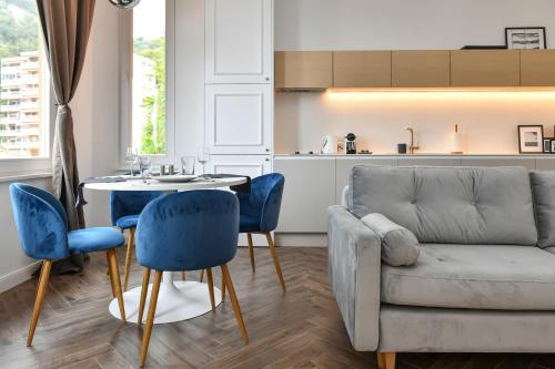 ein Wohnzimmer mit einem Sofa, einem Tisch und Stühlen in der Unterkunft Beautiful Apartment next to Monte Carlo in Beausoleil