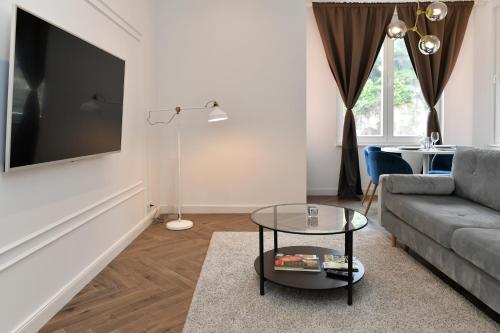 ein Wohnzimmer mit einem Sofa und einem Tisch in der Unterkunft Beautiful Apartment next to Monte Carlo in Beausoleil
