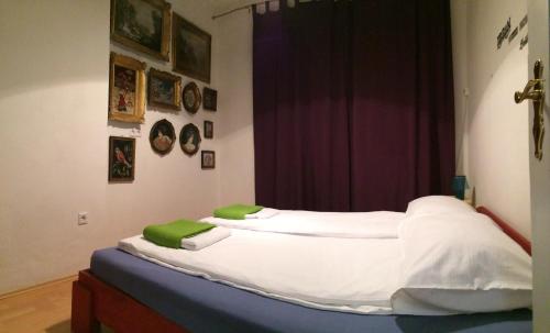 サラエボにあるOrient-Express Apartmentのベッド(白いシーツ、緑の枕付)