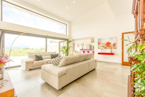 a living room with two couches and a large window at Villa Ca Na Marga in Muro