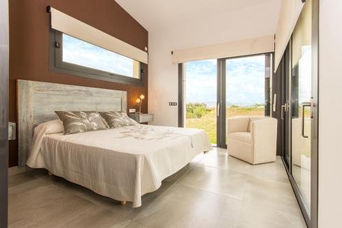ein Schlafzimmer mit einem großen Bett und einem Stuhl in der Unterkunft Villa Ca Na Marga in Muro