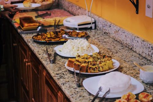 a buffet with plates of food on a counter at Pousada Bons Lençóis in Lençóis