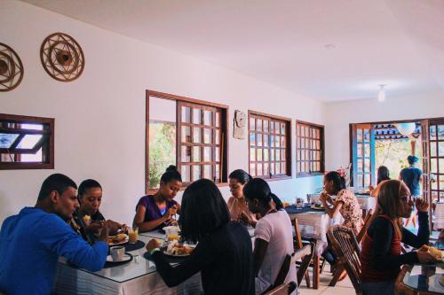 un grupo de personas sentadas en mesas en un restaurante en Pousada Bons Lençóis, en Lençóis