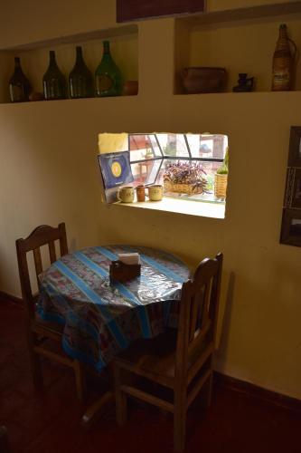a table and chairs in a room with a window at Azul Humahuaca Hostal in Humahuaca