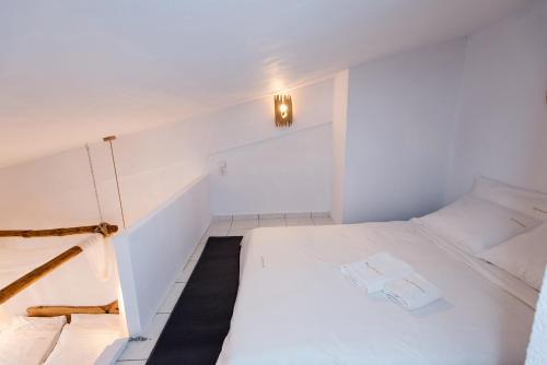 a small white room with a bed and stairs at Blue Mountain Guesthouse by Seablue in Arachova
