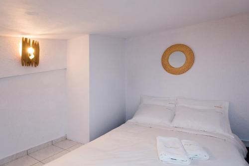 a bedroom with a bed with white sheets and a mirror at Blue Mountain Guesthouse by Seablue in Arachova