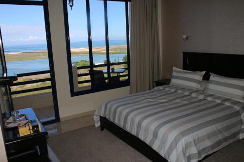 a bedroom with a bed and a view of the ocean at Le temps perdu in Oualidia