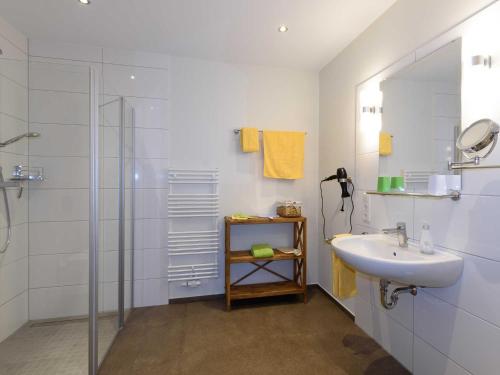 a white bathroom with a sink and a shower at Sielhof Ditzum, 45222 in Ditzum