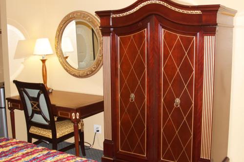 a bedroom with a wooden dresser and a wooden chair at Redondo Beach Inn-LAX in Gardena