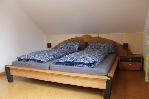 a bed with a wooden frame and pillows on it at Ferienwohnung Hillers, 35218 in Beningafehn