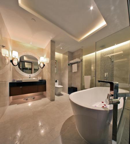 a bathroom with a tub and a sink and a mirror at Grand Skylight International Hotel Shenzhen Guanlan, Near Metro Station, Huawei, Foxcnn, Shenzhen North Railway in Shenzhen