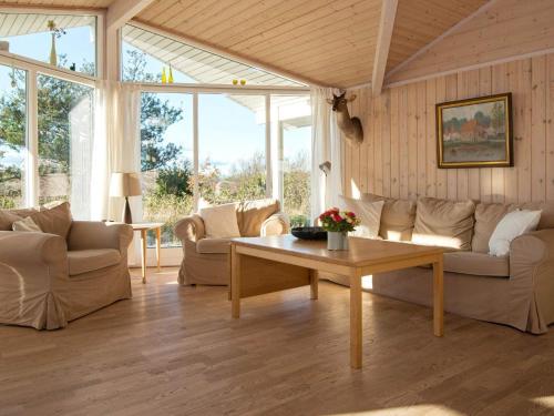 a living room with couches and a coffee table at 6 person holiday home in Knebel in Ørby