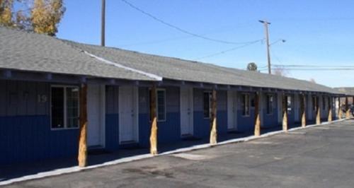 a row of blue and white buildings on a street at Hacienda Motel in Alturas