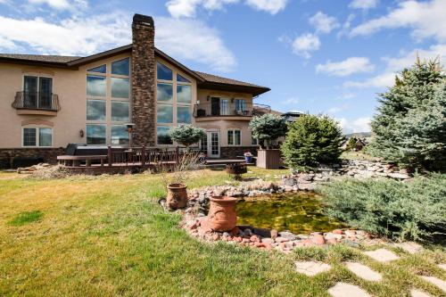 ein Haus mit einem Teich im Hof in der Unterkunft The Timberwolf on Cotton Ranch in Eagle