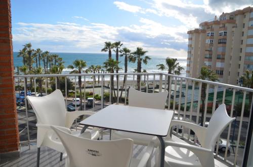 balcón con mesa, sillas y vistas al océano en Estudio FARO TORROX-1ª línea playa, en Torrox Costa