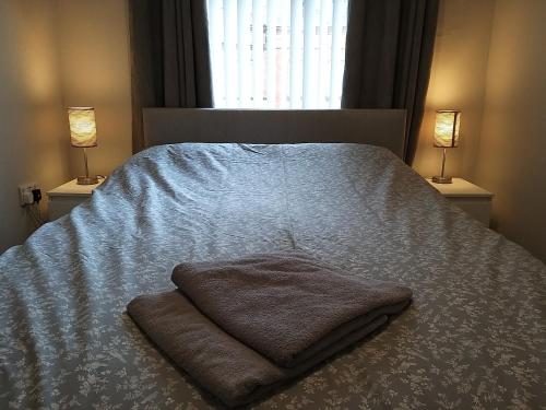 ein Schlafzimmer mit einem Bett mit einer Decke und 2 Lampen in der Unterkunft Templemore Townhouse in Belfast