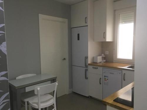 a kitchen with white cabinets and a chair in it at A 5 minutos Estac Tren céntrico y estiloso Vivienda de uso Turistico in Logroño