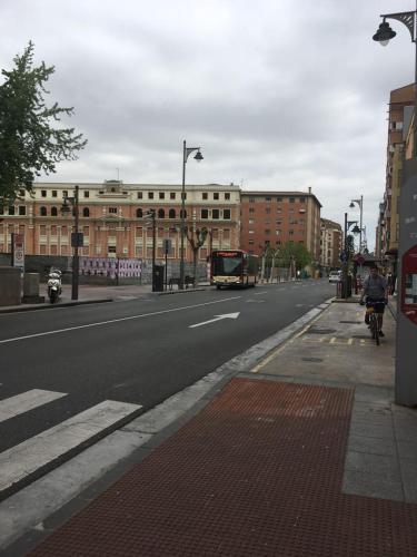 an empty city street with buildings and a person riding a bike at A 5 minutos Estac Tren céntrico y estiloso Vivienda de uso Turistico in Logroño