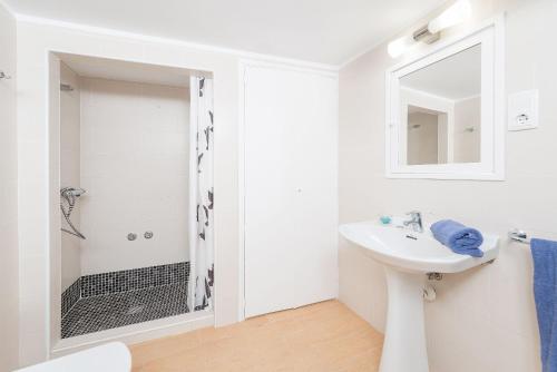 a white bathroom with a sink and a shower at Can M Tatau in Santanyi
