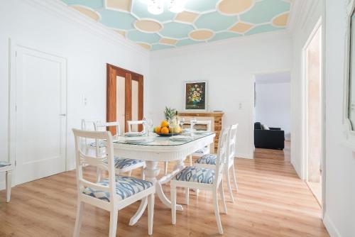 a dining room with a white table and chairs at Can M Tatau in Santanyi