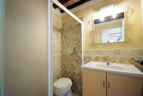 a bathroom with a sink and a toilet and a mirror at Il Villino Isola d'elba-ortano in Rio nellʼElba