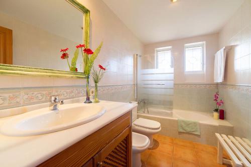 a bathroom with a sink and a toilet and a mirror at Finca Son Garreta in Campanet