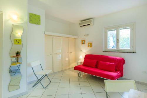 a living room with a red couch and a window at Monolocale casa Lucia in Campo nell'Elba