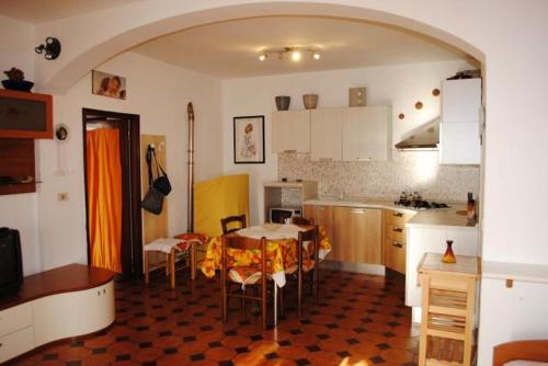 a kitchen with a table and chairs in a room at Appartamento Seccheto Mare in Seccheto