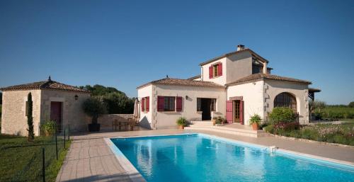 a villa with a swimming pool in front of a house at La Maison in Villeneuve-de-Duras