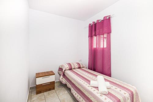 コニル・デ・ラ・フロンテーラにあるApartamento Chiclana 1のベッドルーム(紫色のカーテン付きのベッド1台付)