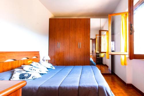 a bedroom with a blue bed and wooden cabinets at Villetta Ivana in Marciana