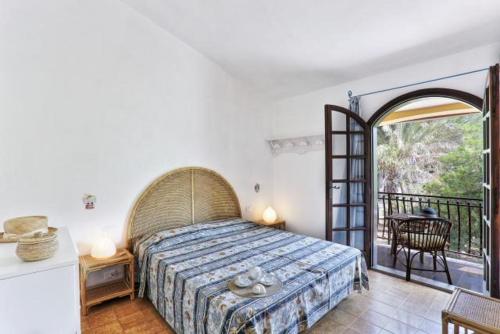 a bedroom with a bed and a balcony at Villa Artistica app.1/trilo 6 (trilocale) in Capoliveri