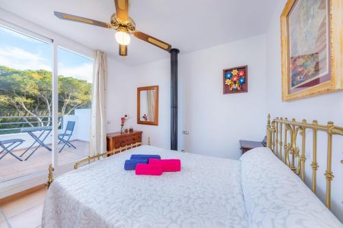 a bedroom with a bed with red and blue pillows on it at Can Bennasar in Can Picafort