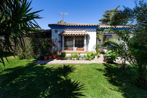 una pequeña casa con un jardín frente a ella en Chalet Diferente, en Chiclana de la Frontera