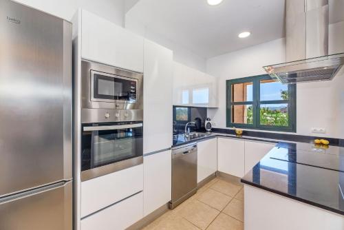 a kitchen with white cabinets and stainless steel appliances at Finca Sa Pradera in Se Casa Blanca