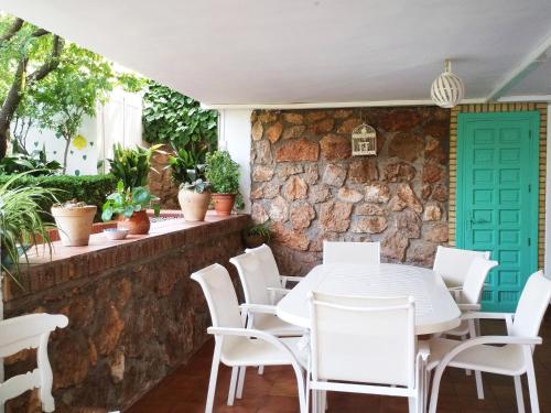 una mesa y sillas frente a una pared de piedra en El jardín de la abuela, en Granada