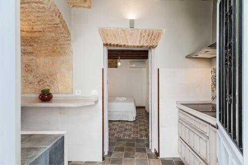 une cuisine aux murs blancs et un couloir avec évier dans l'établissement Casa de los Abuelos 18, à Vejer de la Frontera