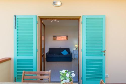 マリーナ・ディ・カンポにあるAppartamento Elbaの青いソファ付きのリビングルームへと続くドア