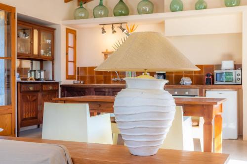 a large white vase sitting on a table with a lamp at Sa Plana in Son Servera