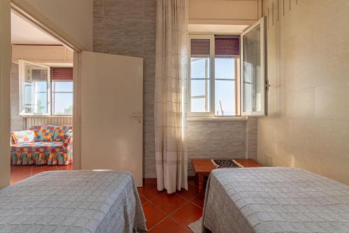 sypialnia z 2 łóżkami, kanapą i oknami w obiekcie Casa Vacanza Marina w mieście Andrano