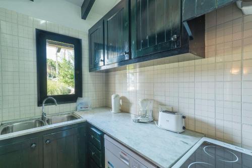uma cozinha com um lavatório e uma bancada em Casa 7 T en Complejo Binisafua em Binisafua